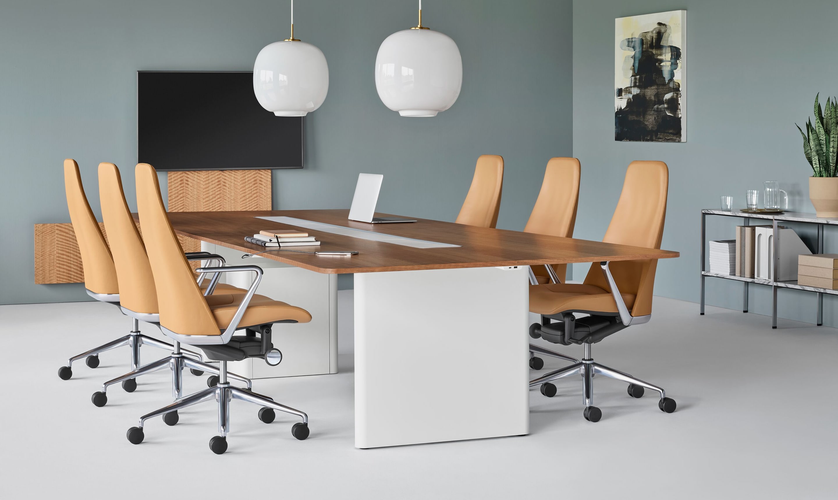 会议室装有矩形Axon会议表和木质顶板,由用骆驼色皮革装饰的六张塔波办公椅环绕
